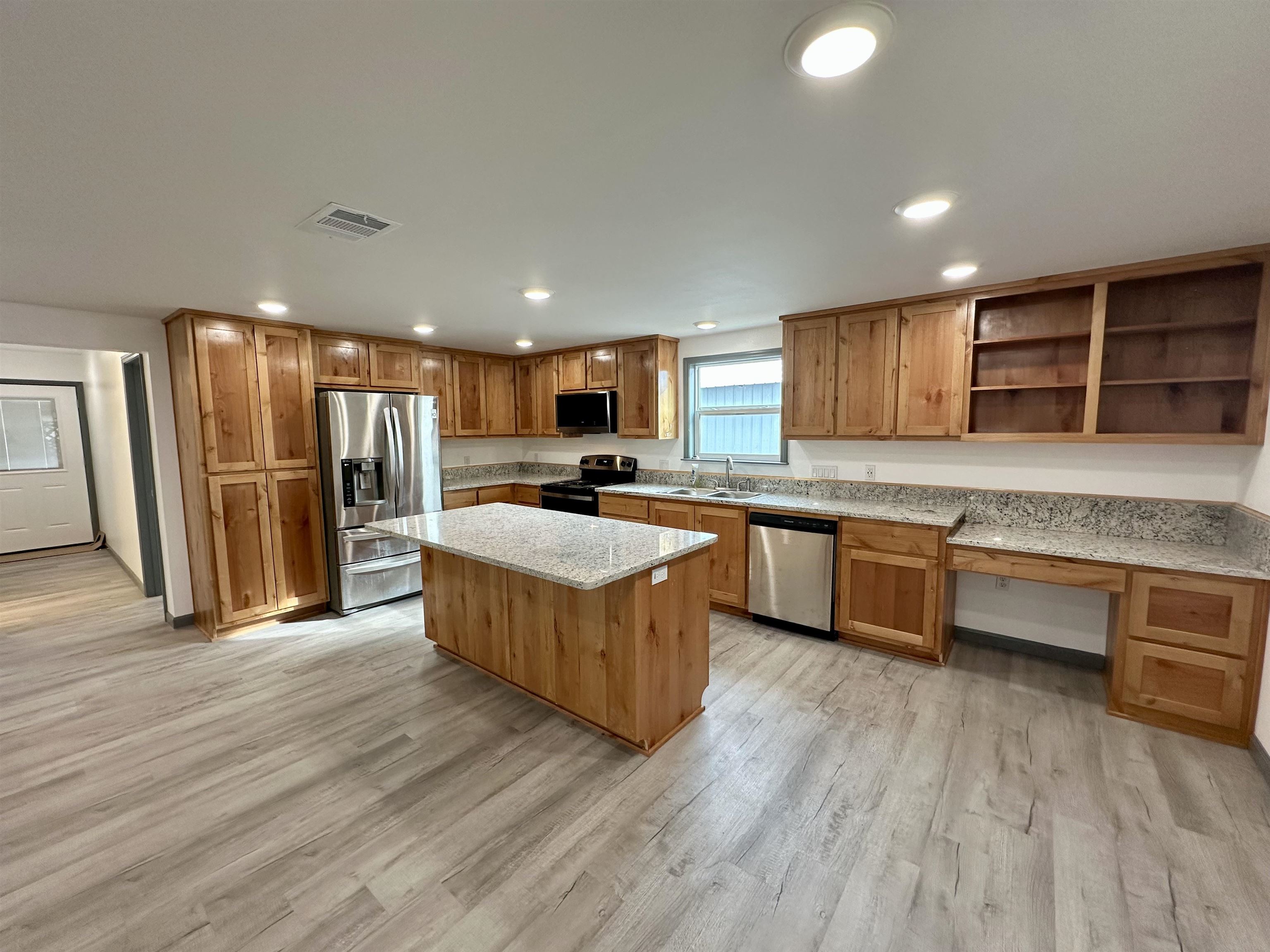 3410 Cactus Trail Kingsland, TX 78639 - Photo 7 of 26 a large kitchen with stainless steel appliances granite countertop a stove a sink and a refrigerator