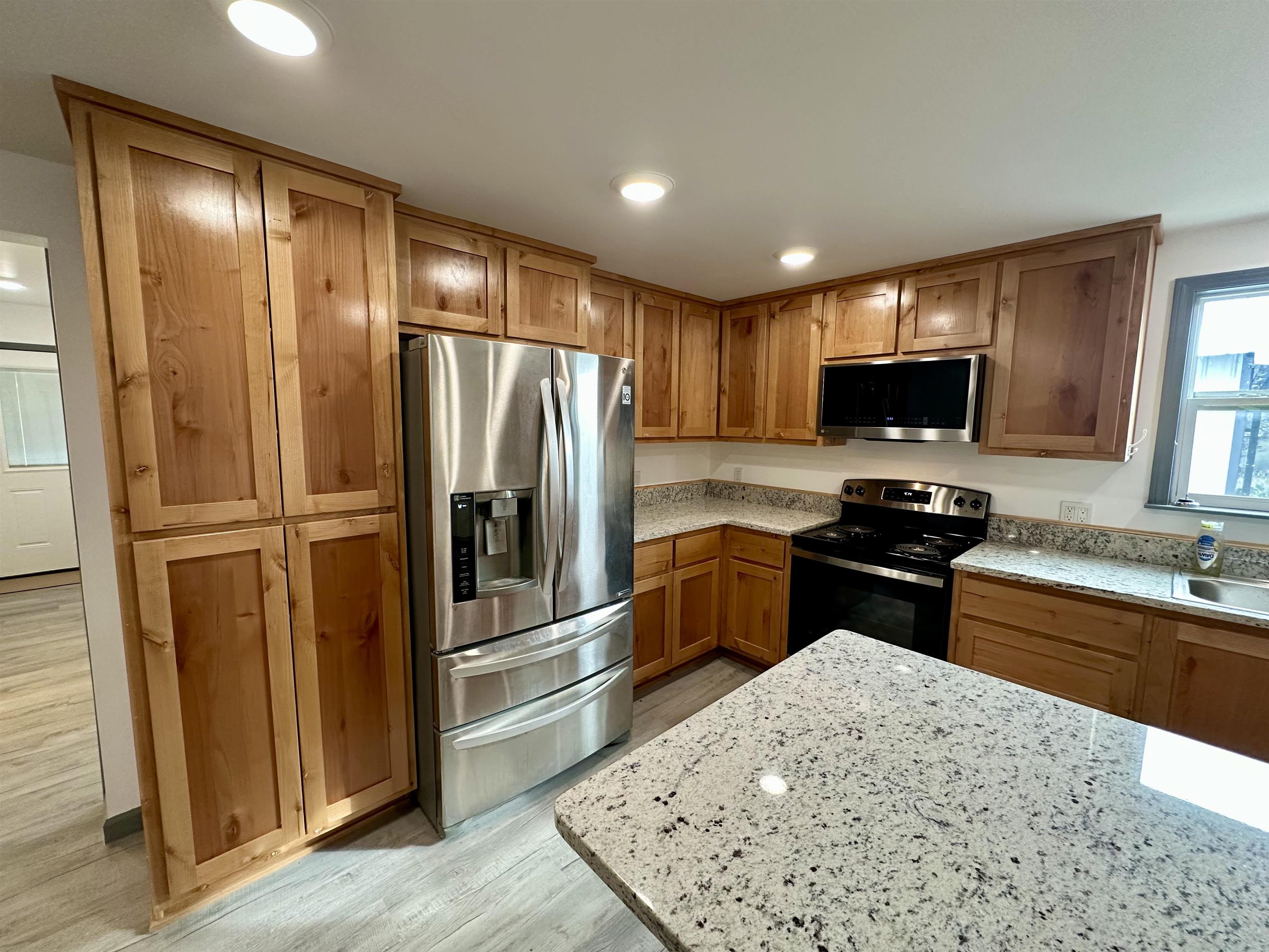 3410 Cactus Trail Kingsland, TX 78639 - Photo 10 of 26 a kitchen with stainless steel appliances wooden cabinets and a refrigerator