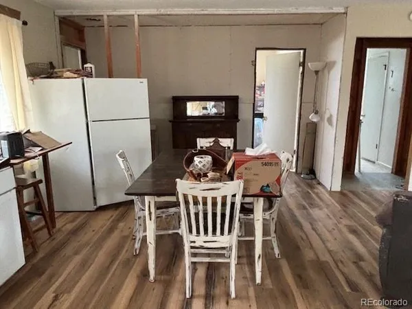 a view of a livingroom with wooden floor and furniture