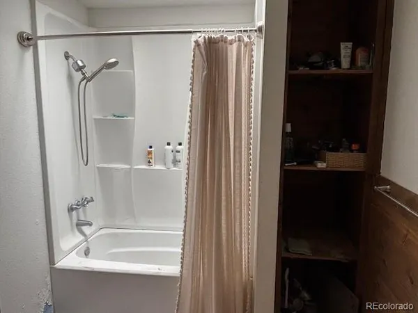a bedroom with a bed and a flat tv screen on wall