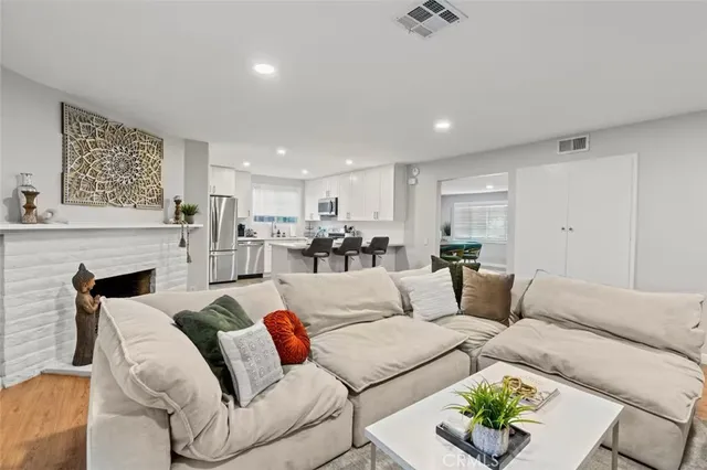 a living room with furniture white walls and kitchen view