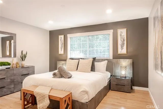 a bedroom with a bed and wooden floor