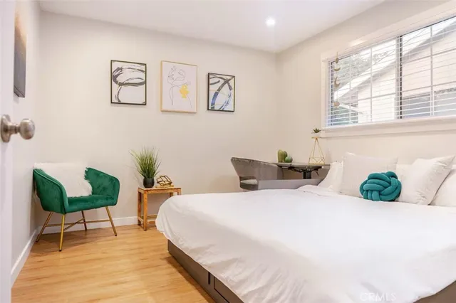 a bedroom with a bed and wooden floor
