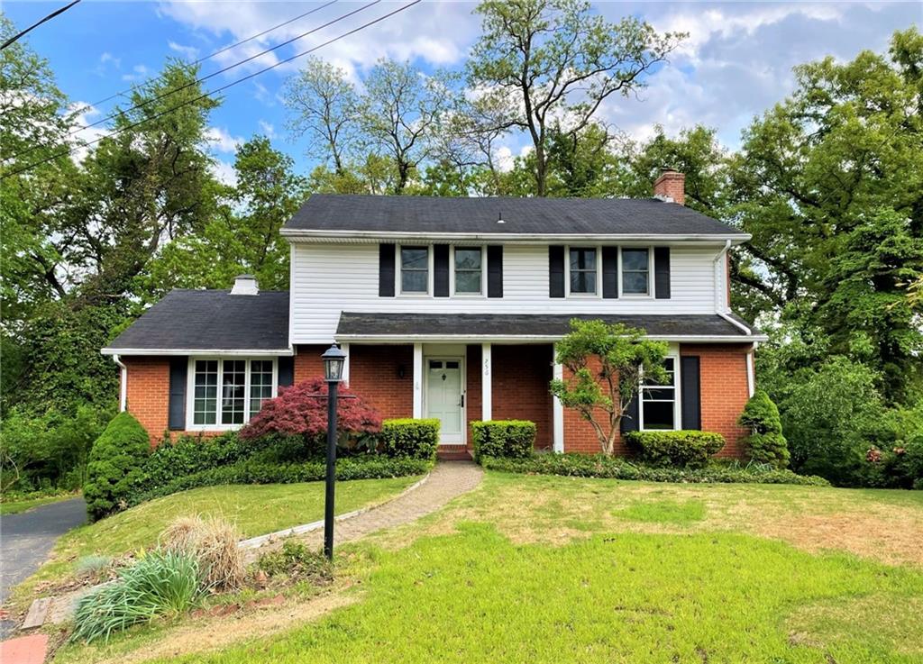 a front view of a house with a garden