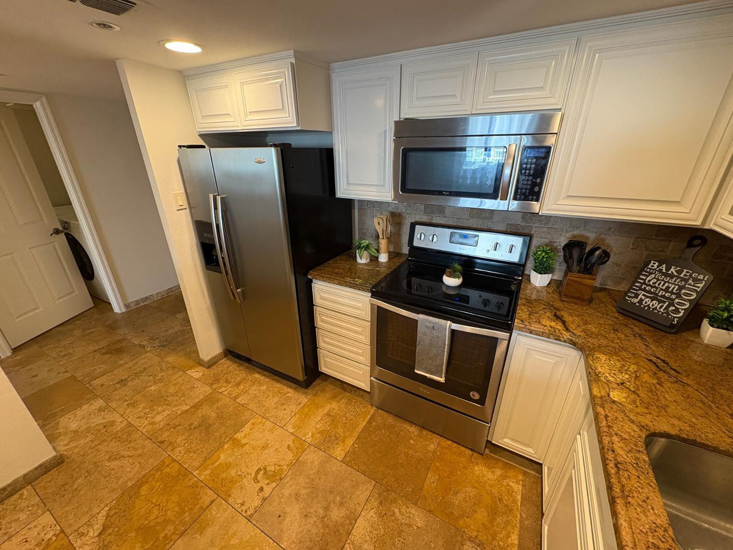 7850 East Camelback Road, Unit 109 Scottsdale, AZ 85251 - Photo 5 of 26 a kitchen with stainless steel appliances granite countertop a refrigerator a stove top oven a sink and dishwasher