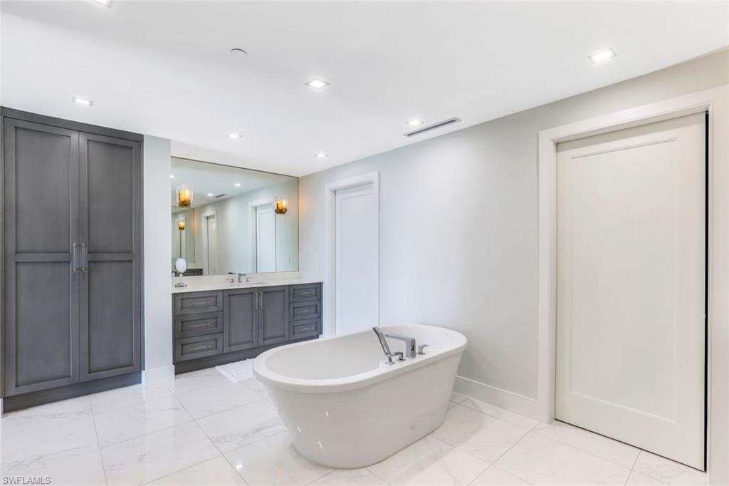 13915 Old Coast Road, Unit 502 Naples, FL 34110 - Photo 14 of 31 a spacious bathroom with a tub shower sink mirror and toilet