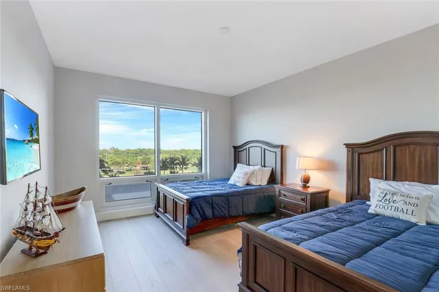 a bedroom with two beds and large window