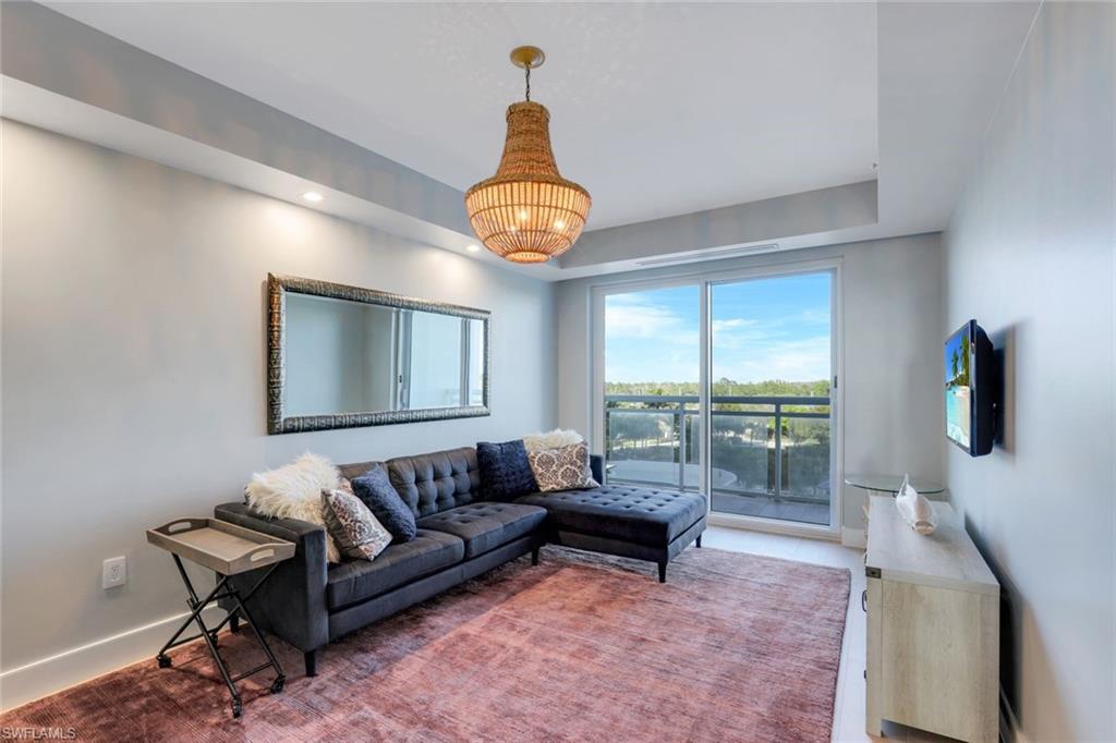 13915 Old Coast Road, Unit 502 Naples, FL 34110 - Photo 20 of 31 a living room with furniture a rug and a large window