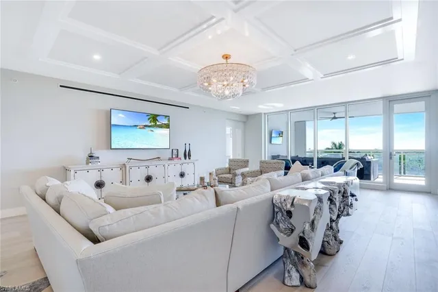 a living room with furniture wooden floor and a chandelier