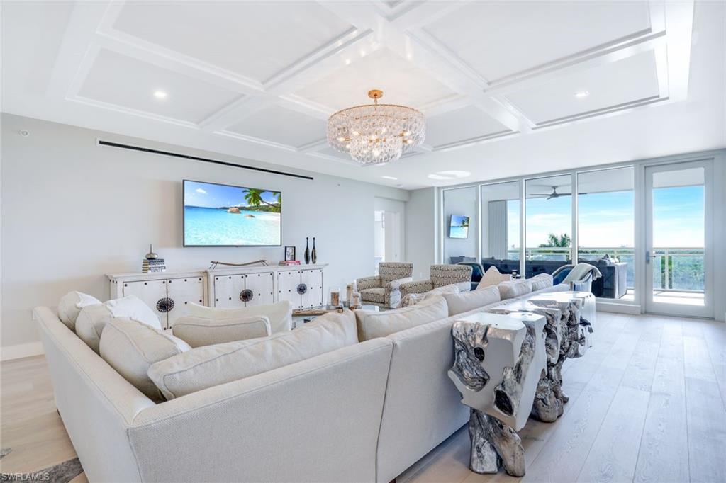 13915 Old Coast Road, Unit 502 Naples, FL 34110 - Photo 3 of 31 a living room with furniture wooden floor and a chandelier