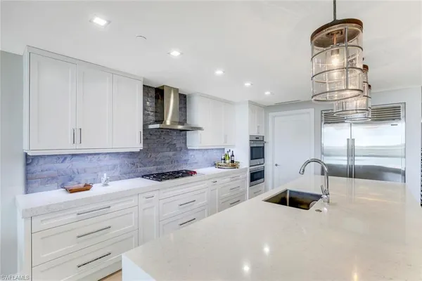 a kitchen with white cabinets and sink