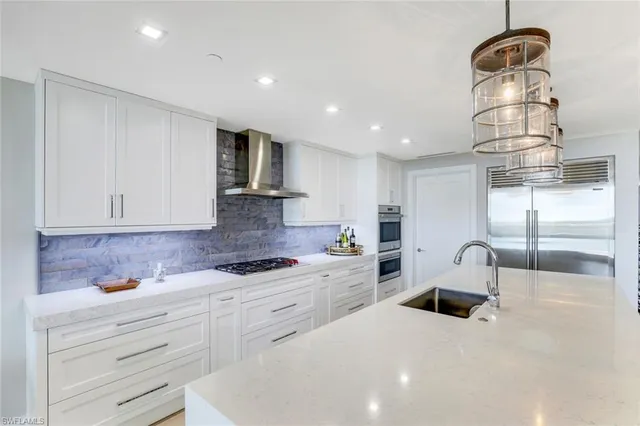 a kitchen with white cabinets and sink