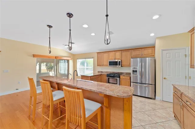 a open kitchen with stainless steel appliances granite countertop a stove and a sink