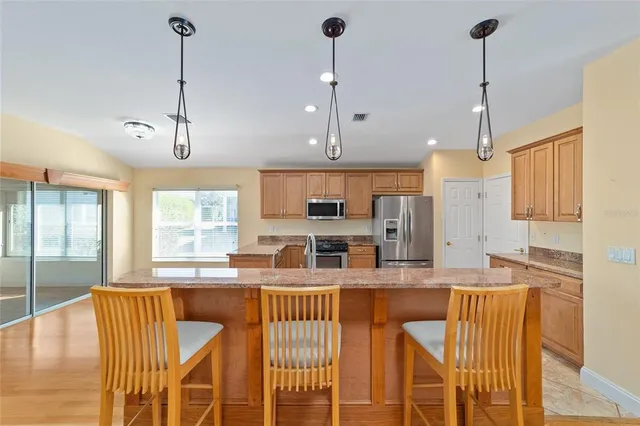 a large kitchen with kitchen island granite countertop a large counter top appliances and a center island