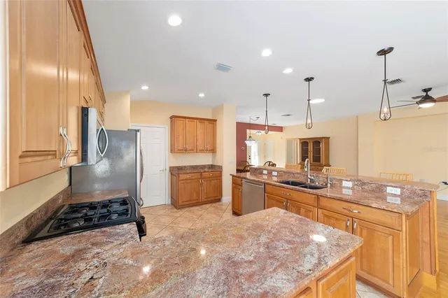 a kitchen with stainless steel appliances granite countertop a refrigerator sink and stove