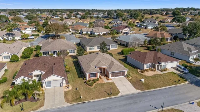 an aerial view of residential houses with outdoor space and parking