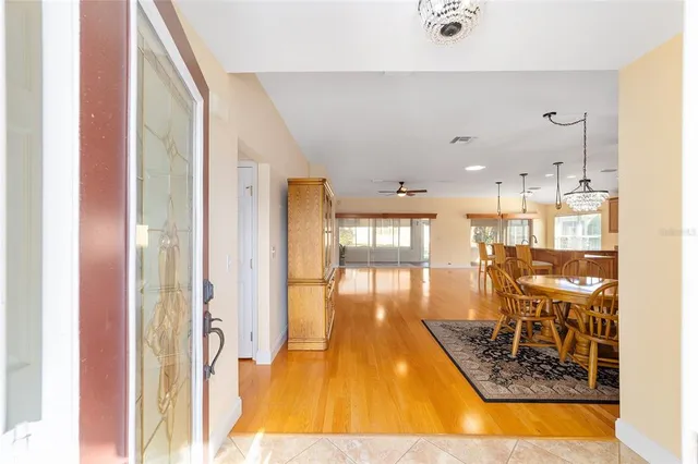 a dining room with furniture a rug and a floor to ceiling window
