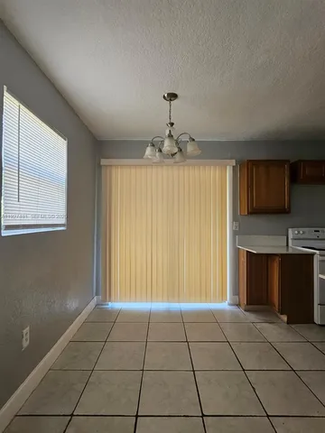 a view of an empty room with a fireplace and a window