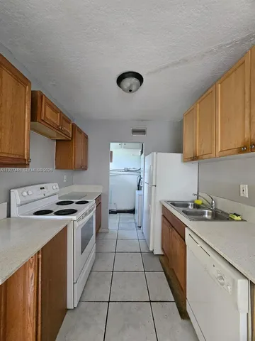 a kitchen with a stove sink and cabinets