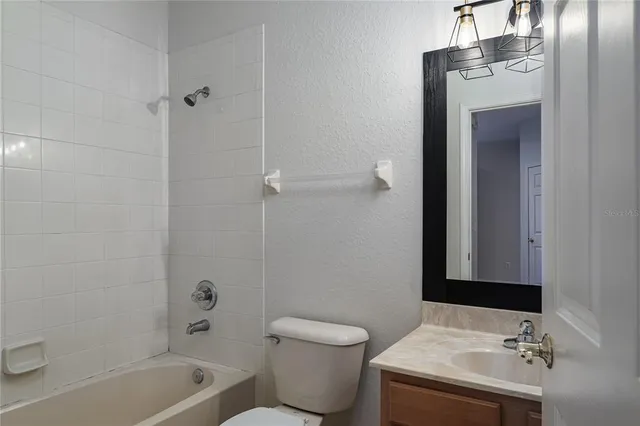 an empty room with wooden floor chandelier fan and windows