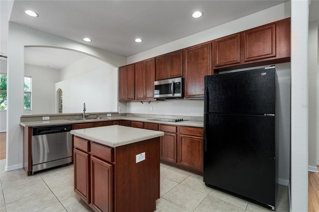 4420 85th Ave Circle East Parrish, FL 34219 - Photo 4 of 40 a kitchen with stainless steel appliances granite countertop a refrigerator a sink and wooden cabinets