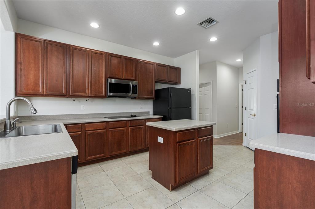 4420 85th Ave Circle East Parrish, FL 34219 - Photo 5 of 40 a kitchen with stainless steel appliances granite countertop wooden cabinets and sink