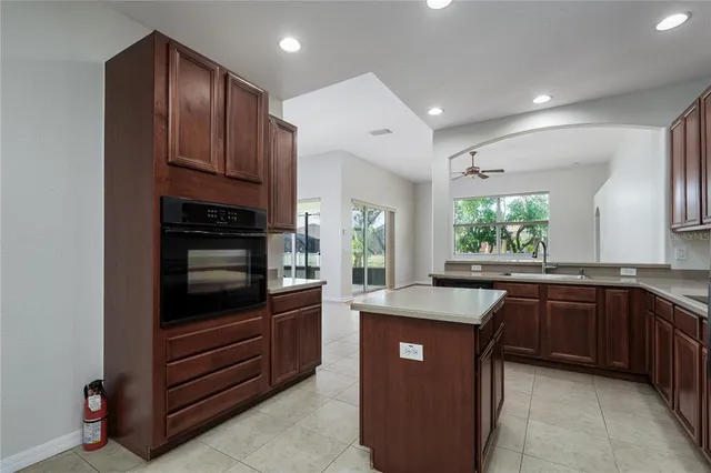 a kitchen with kitchen island granite countertop stainless steel appliances stove sink and cabinets
