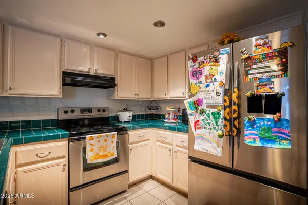 a kitchen with stainless steel appliances granite countertop a refrigerator and a stove top oven