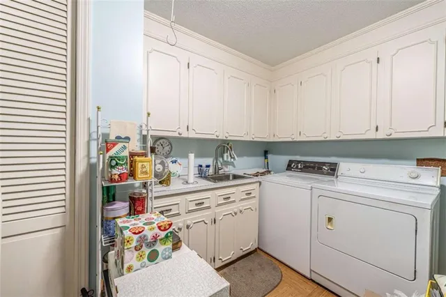 a utility room with stainless steel appliances cabinets and a window