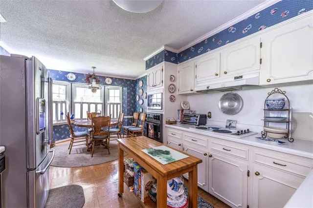 a kitchen with stainless steel appliances granite countertop a stove top oven a sink dishwasher and cabinets with wooden floor