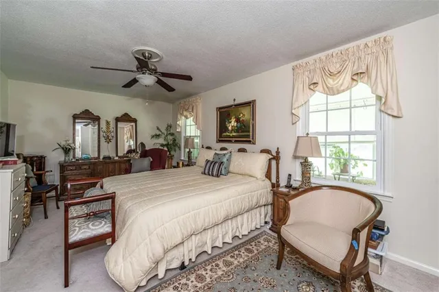 a bedroom with a bed a chandelier and dresser