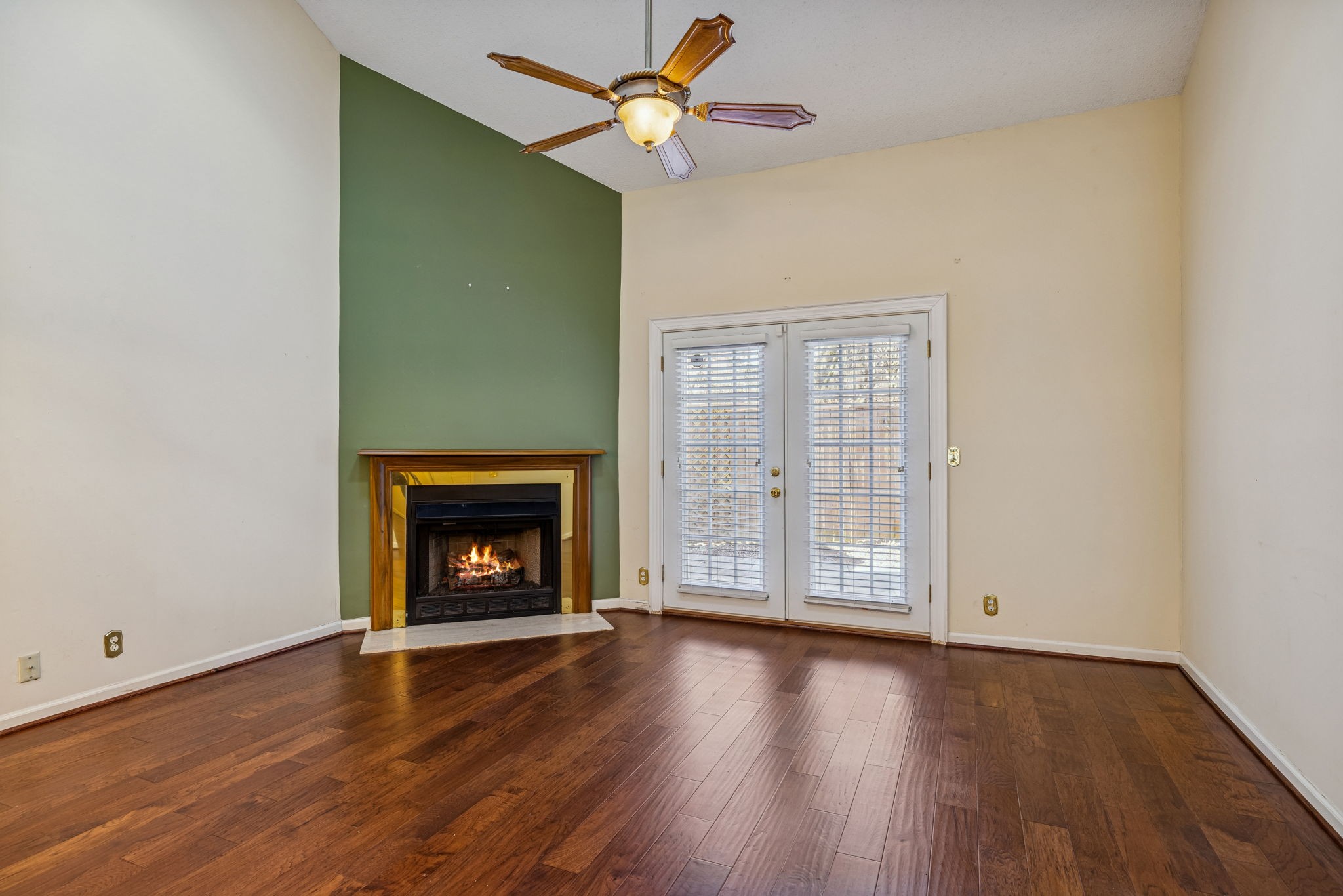 357 Yorkshire Circle Nashville, TN 37211 - Photo 24 of 44 an empty room with wooden floor a ceiling fan a fireplace and windows