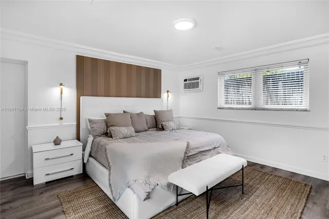 a bedroom with a bed and a flat tv screen on the dresser