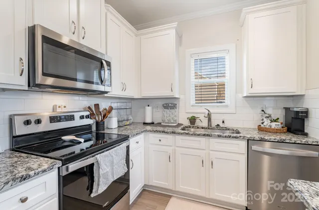 a kitchen with stainless steel appliances granite countertop a stove microwave and sink