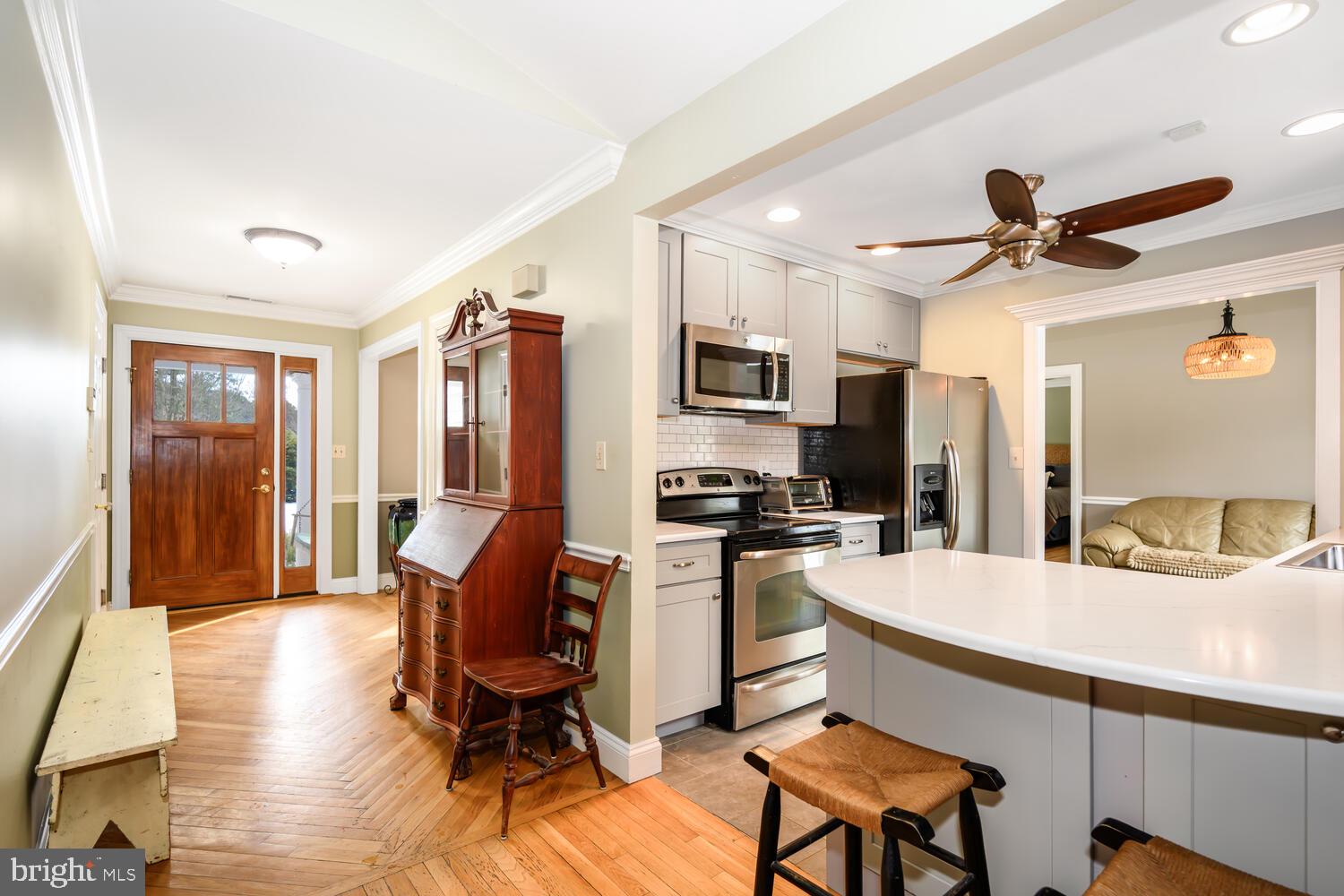 25706 Edgeview Road Royal Oak, MD 21662 - Photo 22 of 31 a kitchen with stainless steel appliances kitchen island granite countertop a refrigerator a stove a sink dishwasher and white cabinets with wooden floor