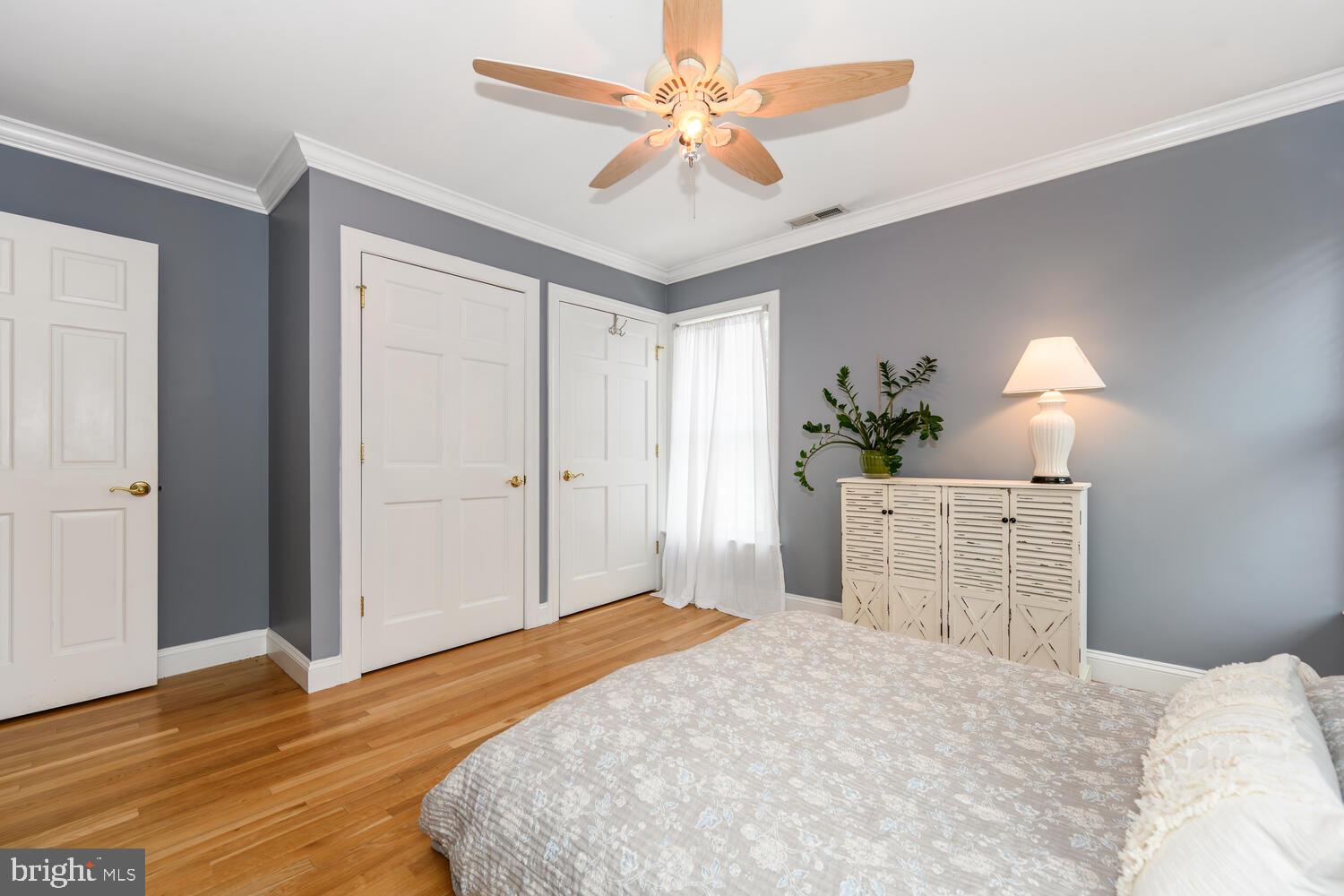 25706 Edgeview Road Royal Oak, MD 21662 - Photo 28 of 31 a bedroom with a large bed a chandelier and a dresser