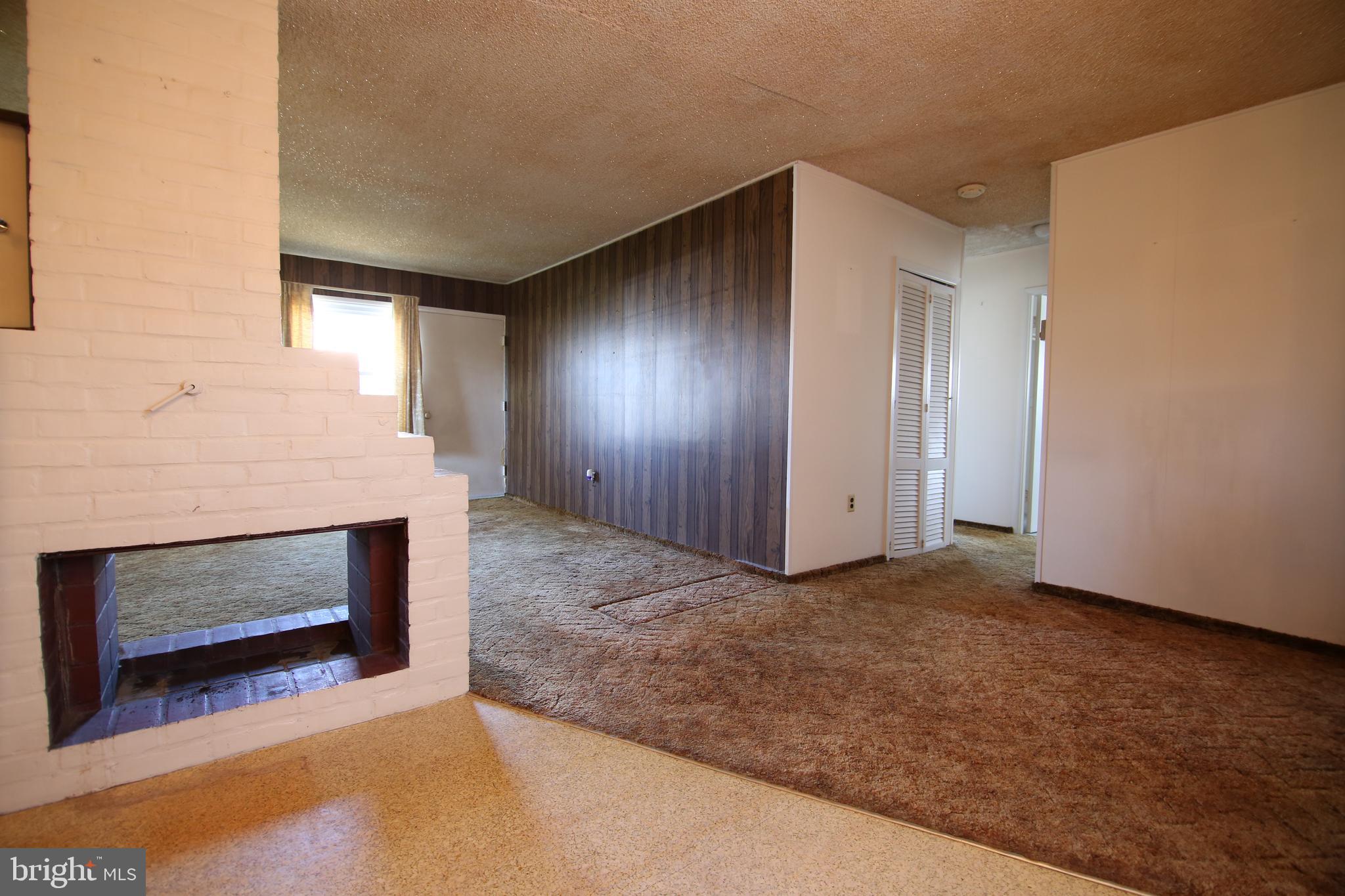 126 Gable Hill Road Levittown, PA 19057 - Photo 6 of 16 a view of an empty room with wooden floor and a fireplace