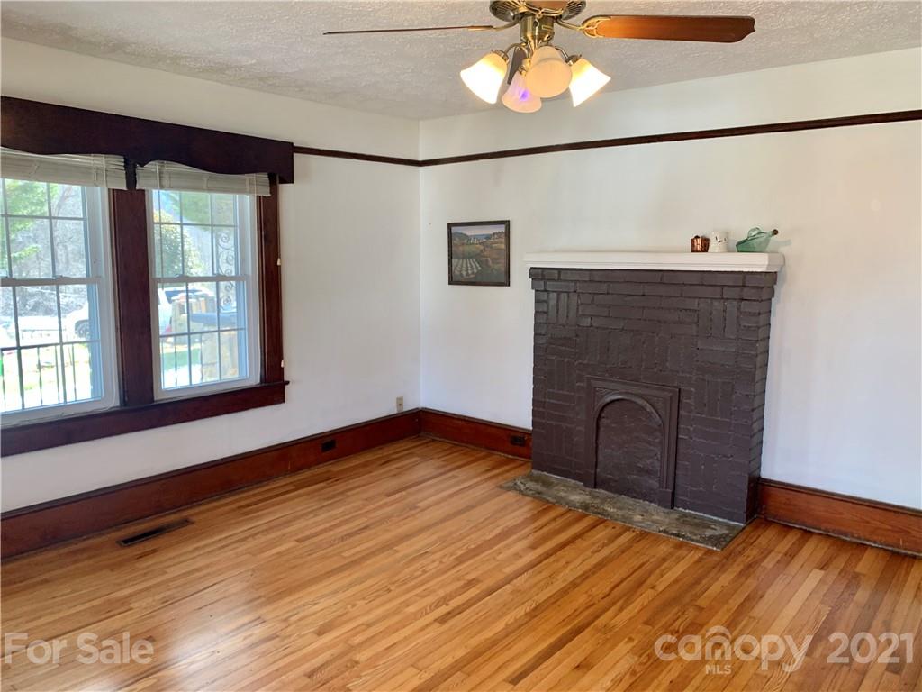 559 Thompson Cove Road Clyde, NC 28721 - Photo 5 of 36 a view of empty room with a fireplace and wooden floor