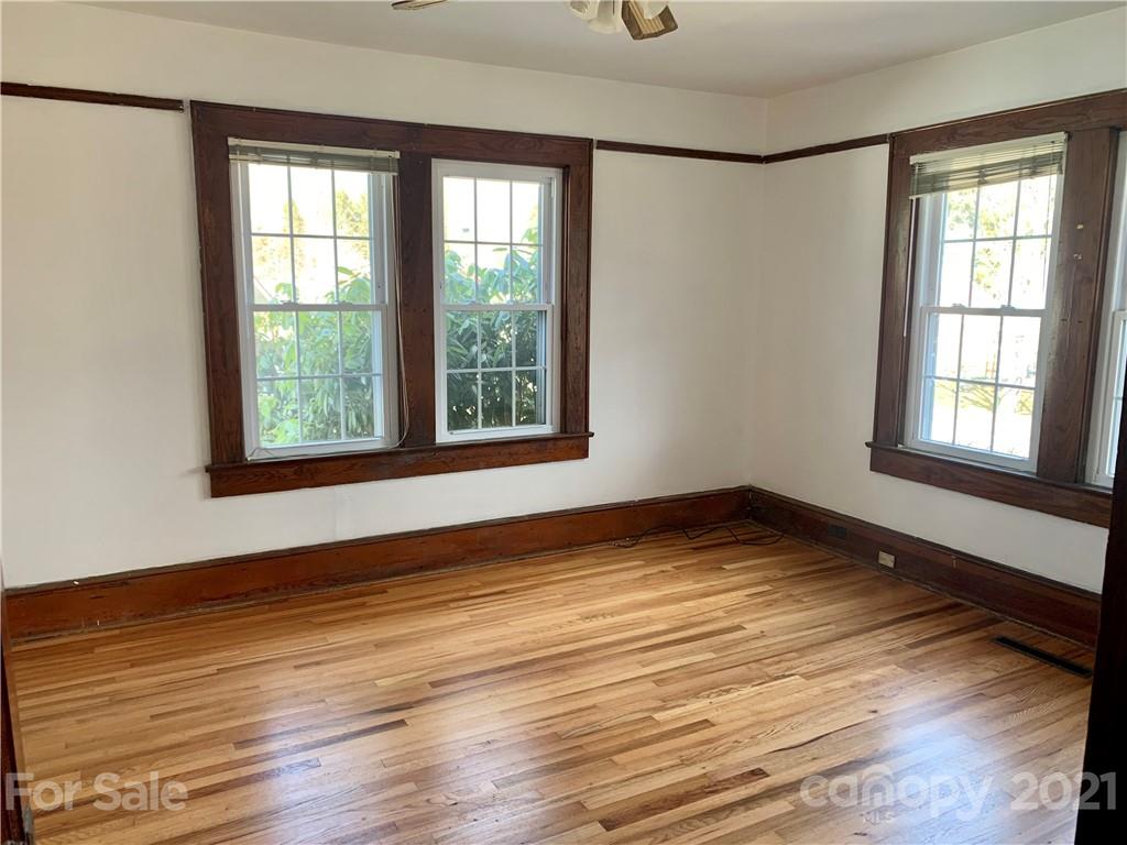 559 Thompson Cove Road Clyde, NC 28721 - Photo 8 of 36 a view of an empty room with wooden floor and a window