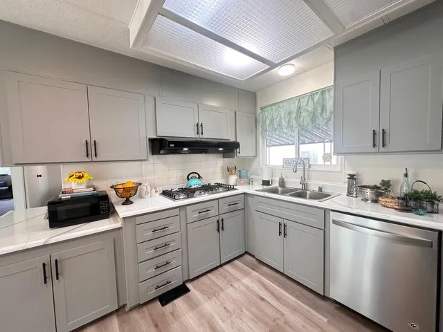 a kitchen with cabinets appliances a sink and a window
