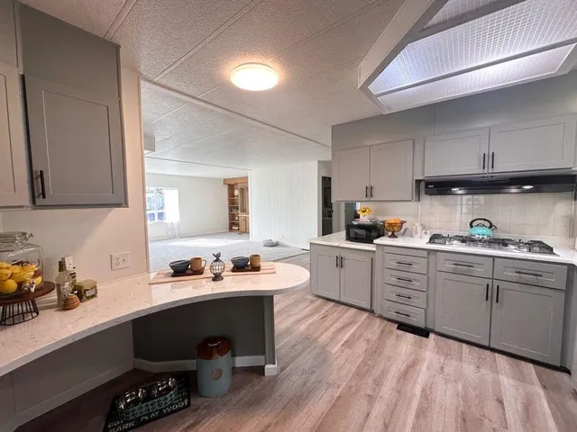 a kitchen with a sink cabinets and wooden floor