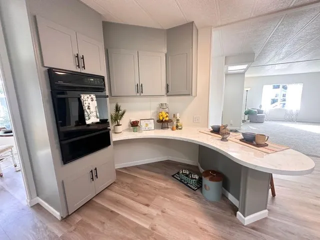 a kitchen with a sink a microwave and cabinets