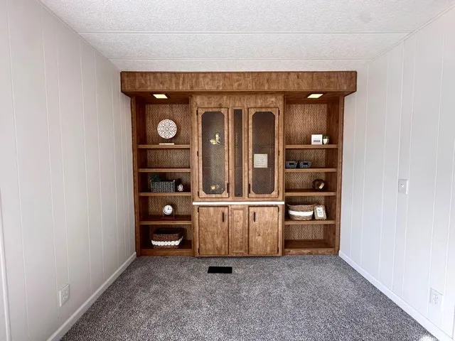a view of an empty room with window and cabinet