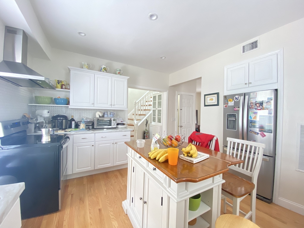 1 Minton Street, Unit 2 Boston, MA 02130 - Photo 2 of 12 a kitchen with stainless steel appliances kitchen island granite countertop a kitchen island hardwood floor and a sink