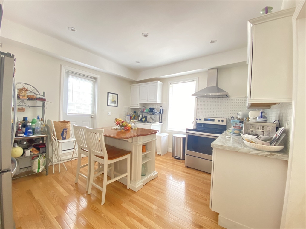 1 Minton Street, Unit 2 Boston, MA 02130 - Photo 3 of 12 a kitchen with a dining table chairs and white appliances