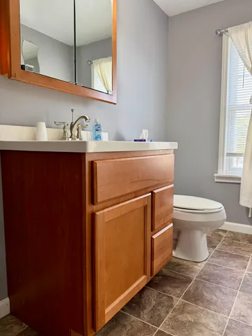 a view of an empty room with window and bathroom