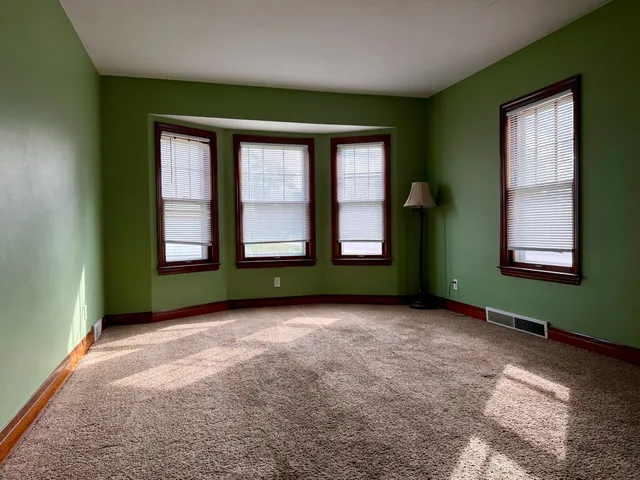 an empty room with windows and closet