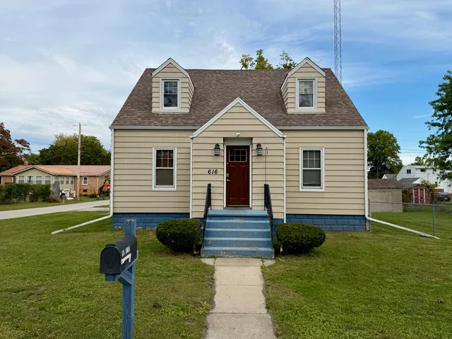 a view of backyard of house with wooden fence