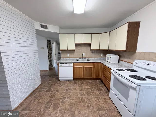 a kitchen with a sink a stove top oven and cabinets