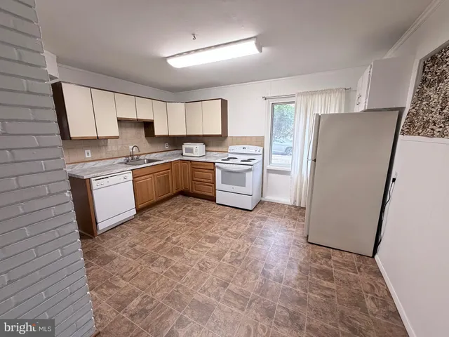 a kitchen with a refrigerator a stove top oven a sink and dishwasher